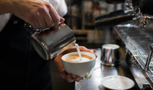 Frische Milch wird in einen Behälter auf einem Bauernhof abgefüllt